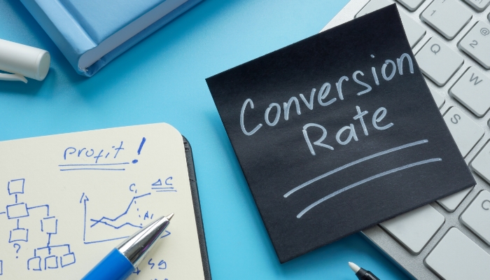 Tastatur, Notizbuch und Notiz mit Conversion Rate