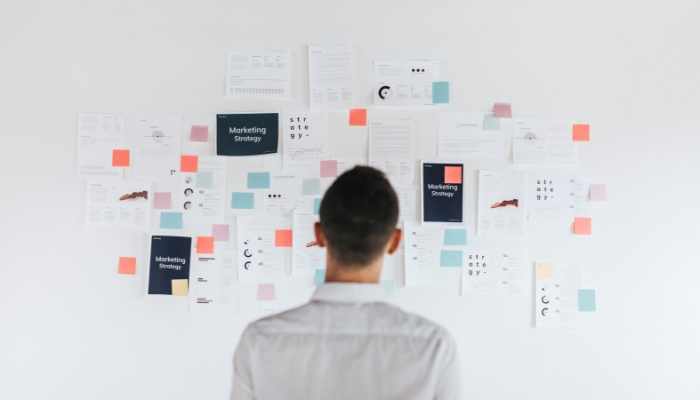 Mann steht vor Content-Plan an der Wand